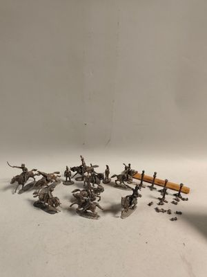 quelques figurines en argent représentant des soldats et des chevaux sont posées sur une surface blanche