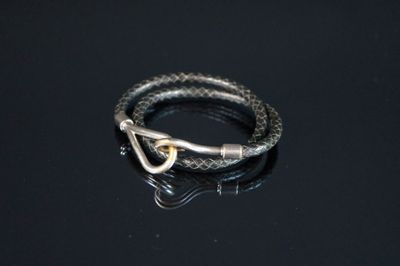 une image représentant un bracelet muni d'un fermoir, posé sur une surface noire