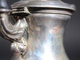 a silver vase with a handle on a black background