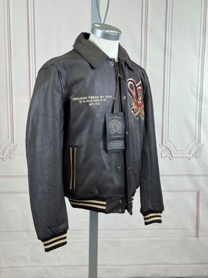 une veste en cuir posée sur un mannequin devant un mur blanc