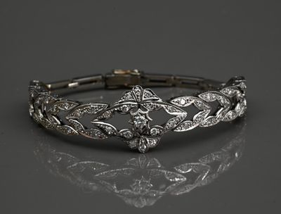 un gros plan d'un bracelet en diamants posé sur une surface réfléchissante