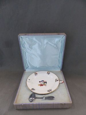 une assiette blanche dans un étui bleu, avec une cuillère et une fourchette