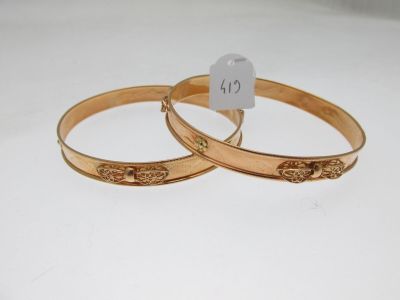 pair of gold tone bangles with engraved design on each side