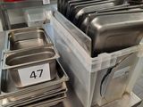 several trays of food are stacked on a table in a kitchen