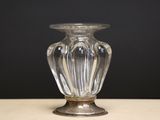 a glass vase sitting on a table with a black background