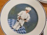 three plates with a painting of a chef on them on a table