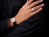 the woman is wearing a black shirt and a gold watch