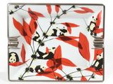 a panda bear sitting on a branch with red leaves