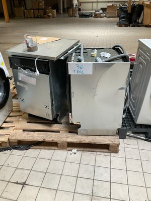 deux machines à laver posées sur une palette dans un entrepôt
