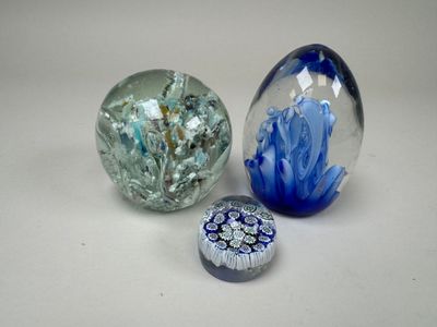 trois billes de verre posées sur une table l'une à côté de l'autre
