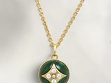 a gold necklace with a green and white pendant on a gold chain