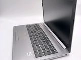 a silver laptop with a black keyboard on a white surface