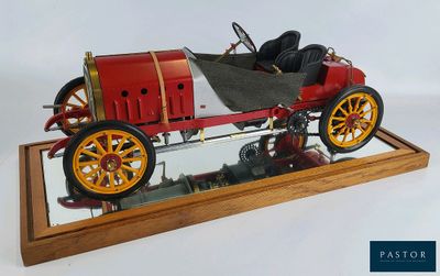 une petite maquette de voiture exposée sur un socle en bois