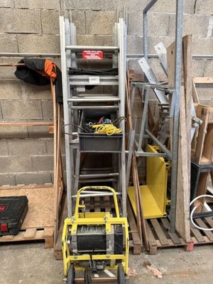 une petite machine jaune posée à côté d'un tas de bois