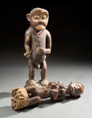 statue d'un singe debout au sommet d'un tas de bois