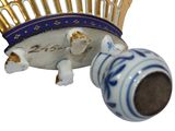 a small blue and white vase with a gold crown on it