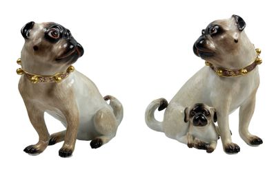 deux figurines de carlins assis l'une à côté de l'autre sur une surface blanche