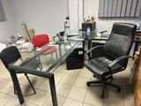 a glass desk with a chair and a computer on it