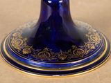 a blue vase with gold decoration on it on a table