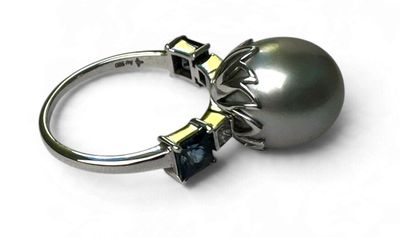 une image d'une bague en perles et diamants sur fond blanc
