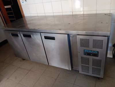 a stainless steel counter top with three doors and a freezer