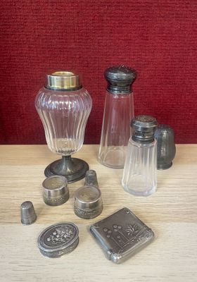 bottles and salt shakers sitting on a table with a red background