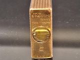 a gold lighter sitting on top of a black table