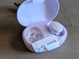 a pair of ear buds in a case on the floor