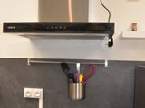 une cuisine équipée d'une cuisinière et d'une hotte aspirante