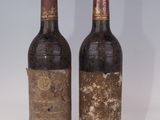 deux bouteilles de vin posées l'une à côté de l'autre sur une surface blanche