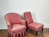 pair of pink upholstered chairs with ruffled skirt