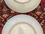 two plates that are sitting on a red rug
