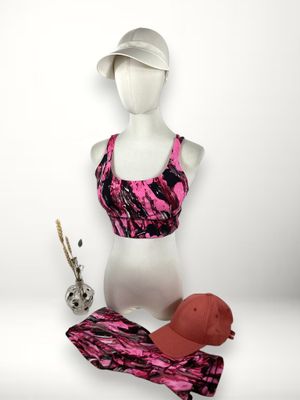mannequin féminin portant un brassière de sport rose et une casquette rose