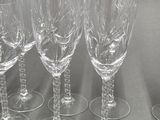 six empty wine glasses are lined up on a table