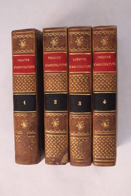trois vieux livres sont alignés sur une surface blanche
