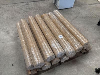 de nombreux rouleaux de carton posés sur une palette dans un entrepôt