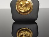 a close up of a gold coin on a black surface