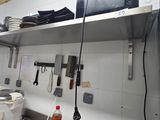 many pots and pans on the shelves in the kitchen