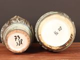 pair of antique chinese vases sitting on top of a wooden table