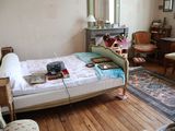 une chambre avec un lit, une chaise, un bureau et un miroir