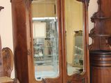 a large wooden cabinet with a mirror on top of it