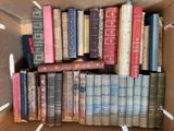 une boîte remplie de vieux livres empilés les uns sur les autres