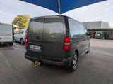 a grey van parked in a parking lot under a blue umbrella