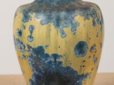 a blue and yellow vase sitting on a table
