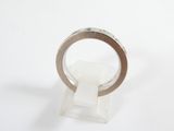 silver ring with a thin band on a clear stand
