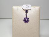 une image représentant un collier auquel est suspendue une fleur violette sur le côté
