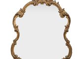 un grand miroir doré orné de sculptures élaborées et d'une croix sur le dessus