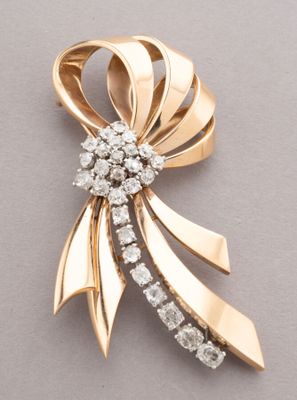 an image of a gold and diamond bow brooch