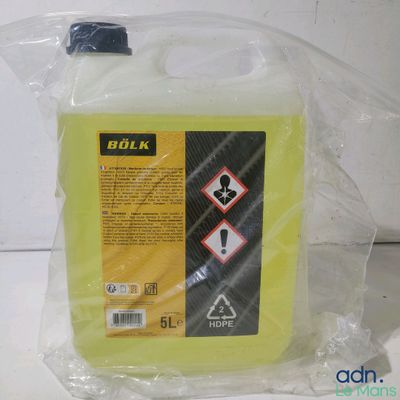 un gros plan d'une bouteille contenant un liquide jaune posée sur une table
