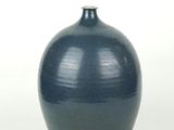 a blue vase that is sitting on a white surface